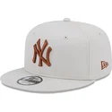 beige-snapback-kasket-med-flad-skygge-og-brunt-logo-9fifty-league-essential-fra-new-york-yankees-mlb-af-new-era