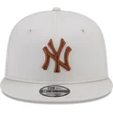 beige-snapback-kasket-med-flad-skygge-og-brunt-logo-9fifty-league-essential-fra-new-york-yankees-mlb-af-new-era