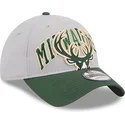 gra-og-gron-justerbar-kurvet-kasket-9twenty-tip-off-2023-fra-milwaukee-bucks-nba-fra-new-era